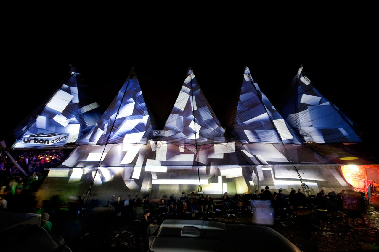 Weite Außenansicht des Urban-Art-Forms-Festivalzelts mit geometrischen PANI-Projektionen