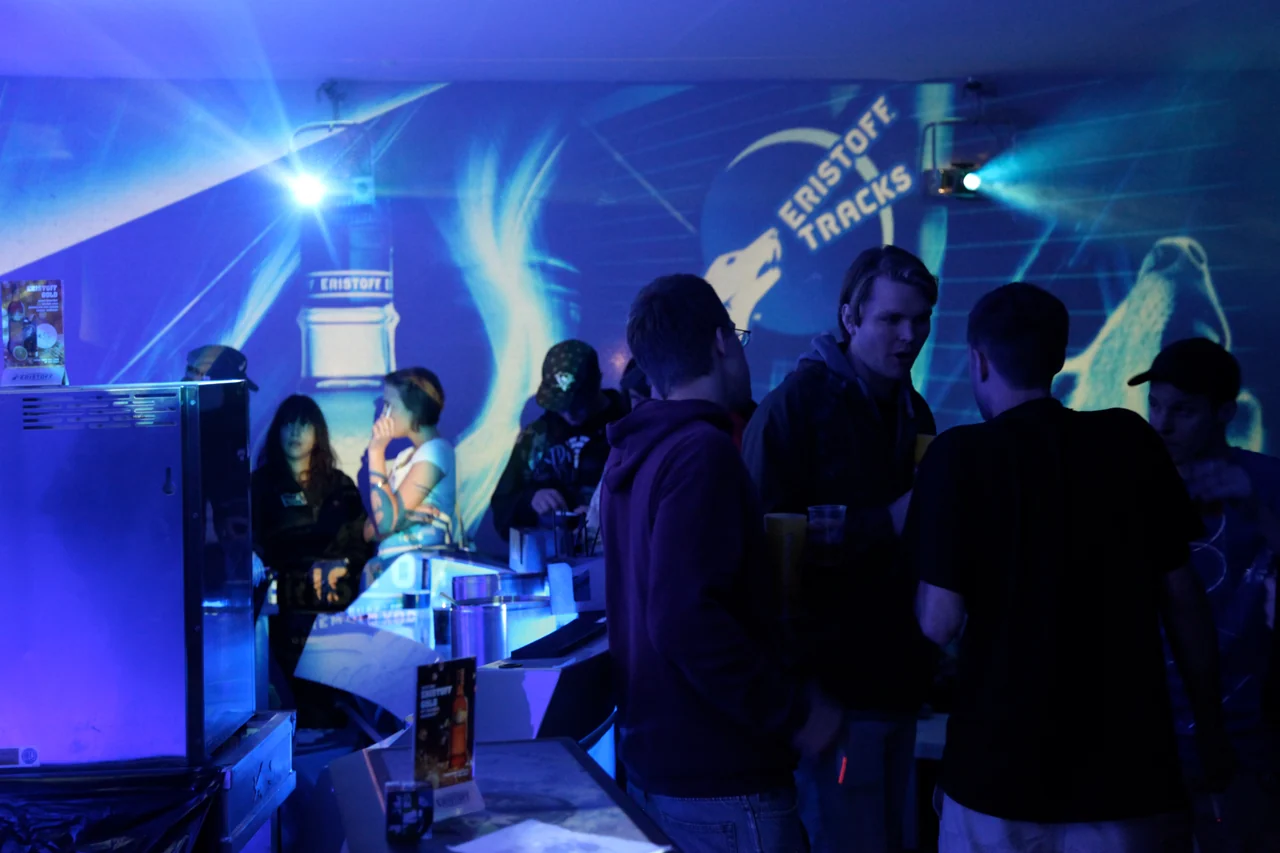 Bar und Gäste vor blauen Eristoff-Visuals mit sichtbaren Projektionsstrahlen