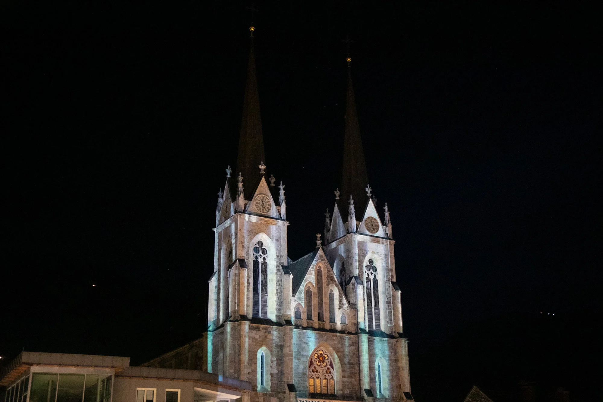 Weiße und orange Projektionsmotive auf der Domfassade bei Nacht