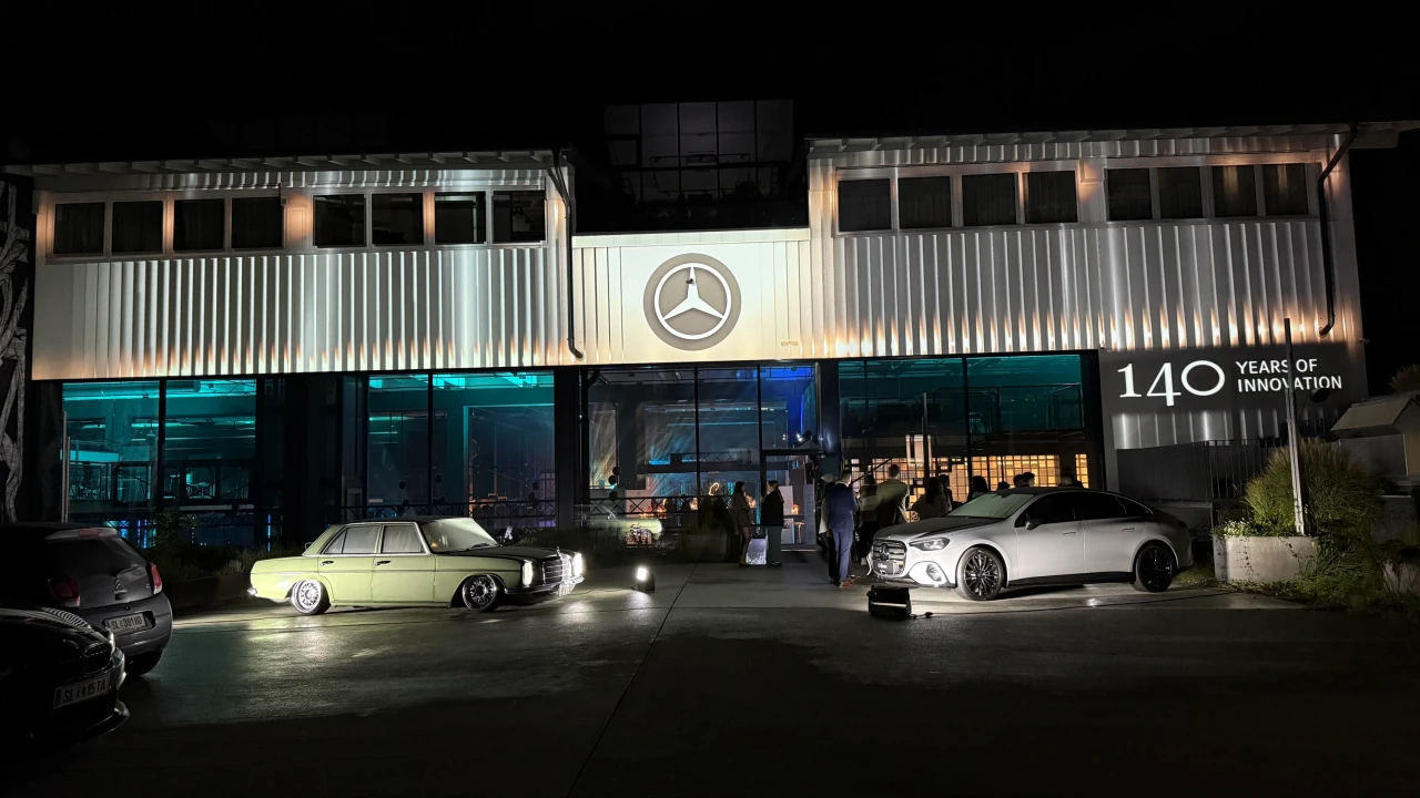Feine weiß-goldene Lichtstreifen rahmen den großen Mercedes-Stern über dem Eingang ein