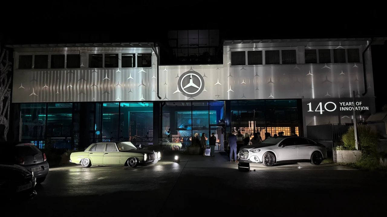 Muster aus kleinen Mercedes-Sternen und weichen vertikalen Lichtstreifen auf der Gebäudefassade