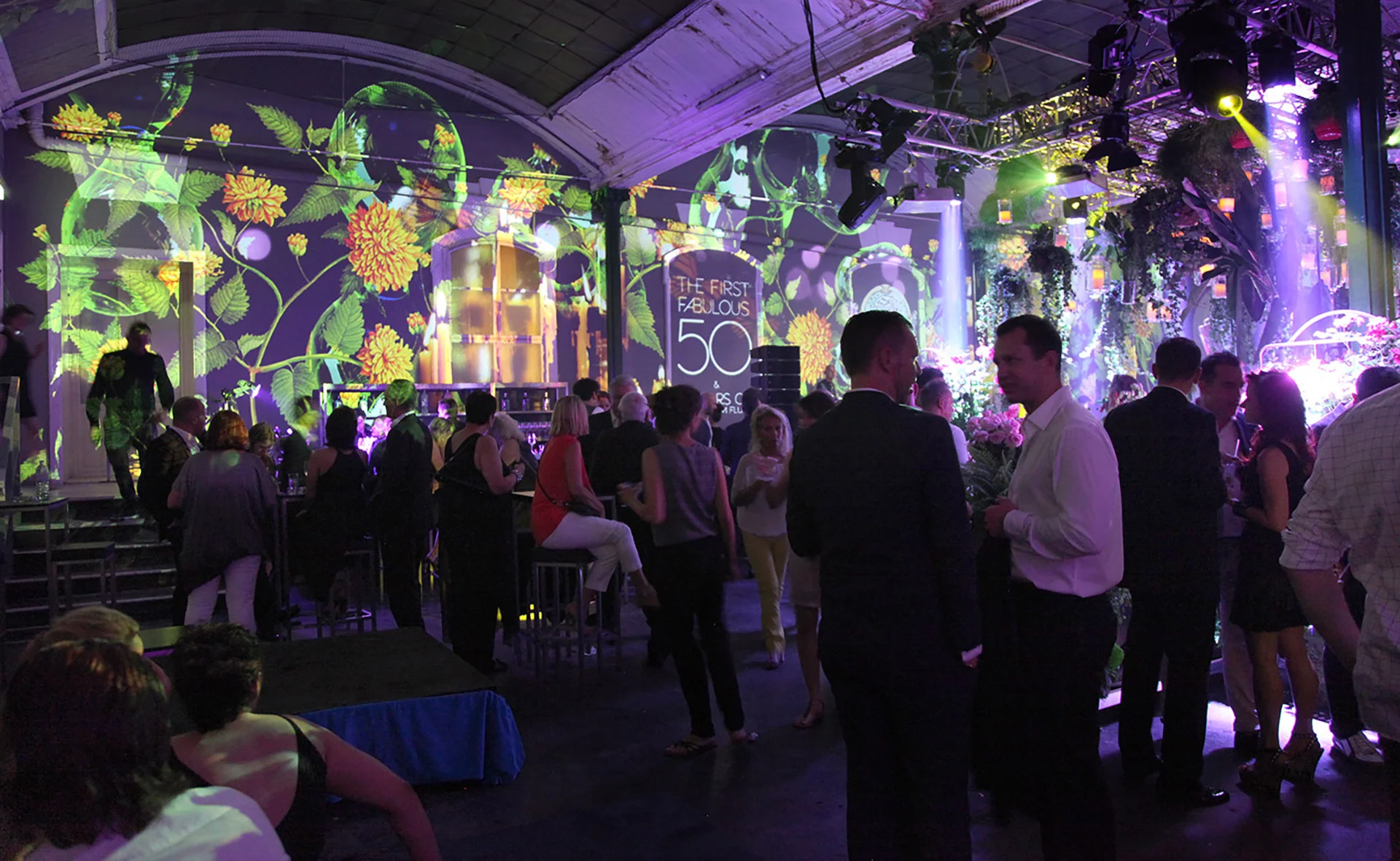 Green and yellow plant motifs projected on the walls behind guests
