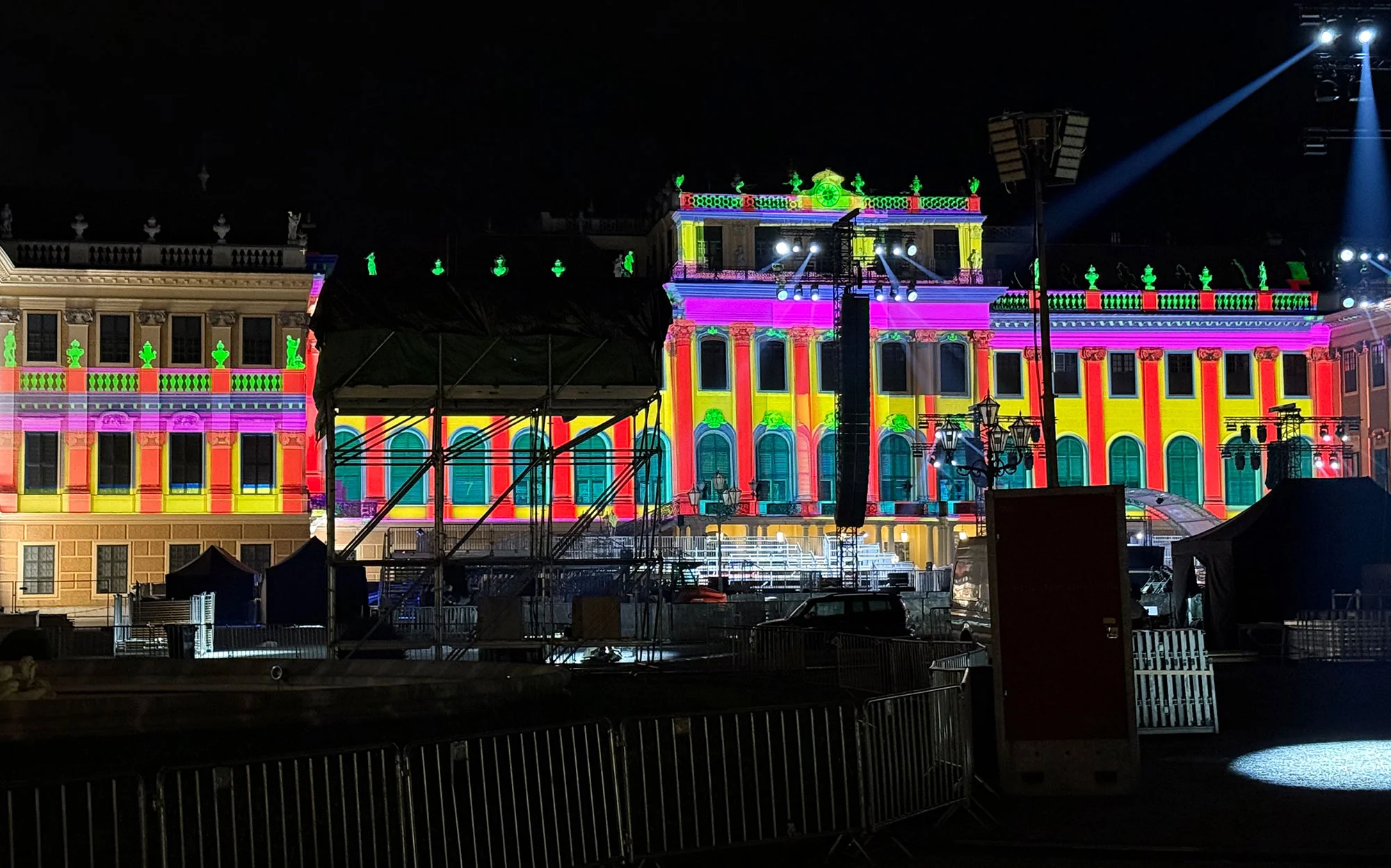 Colourful geometric visuals on the palace facade behind the concert stage