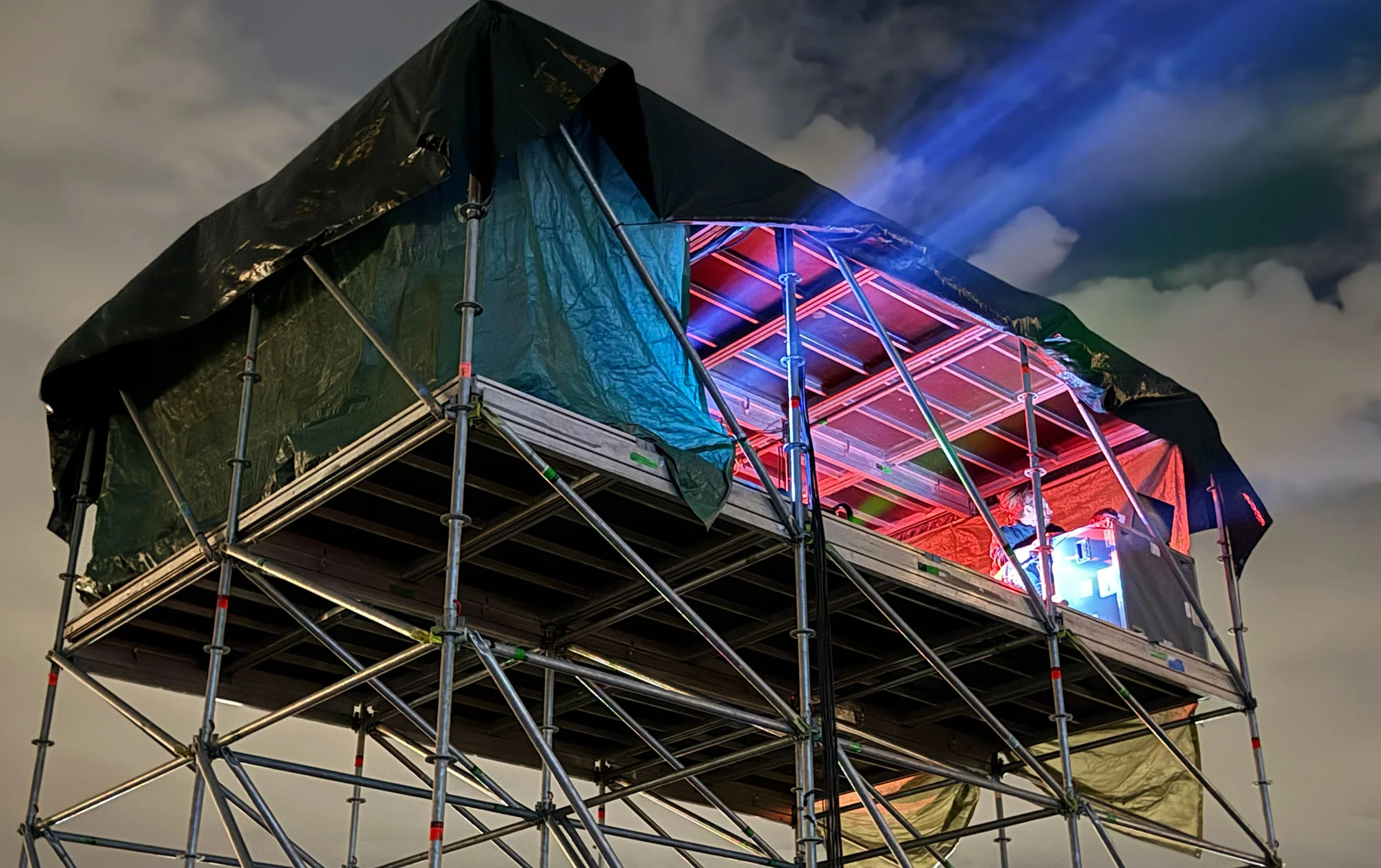Projection equipment on a scaffold platform with a light beam into the sky