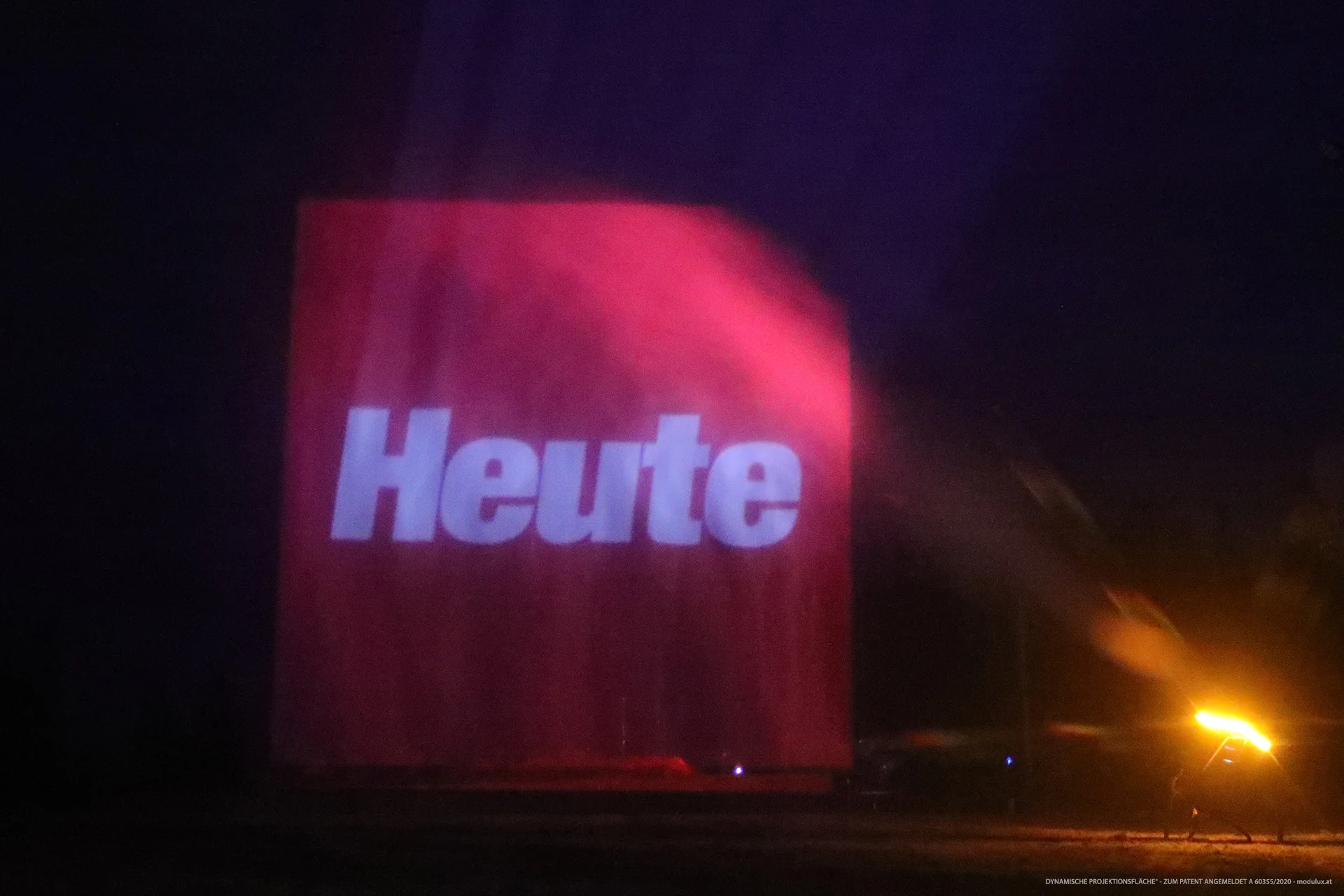 Red Heute logo projected onto water particles