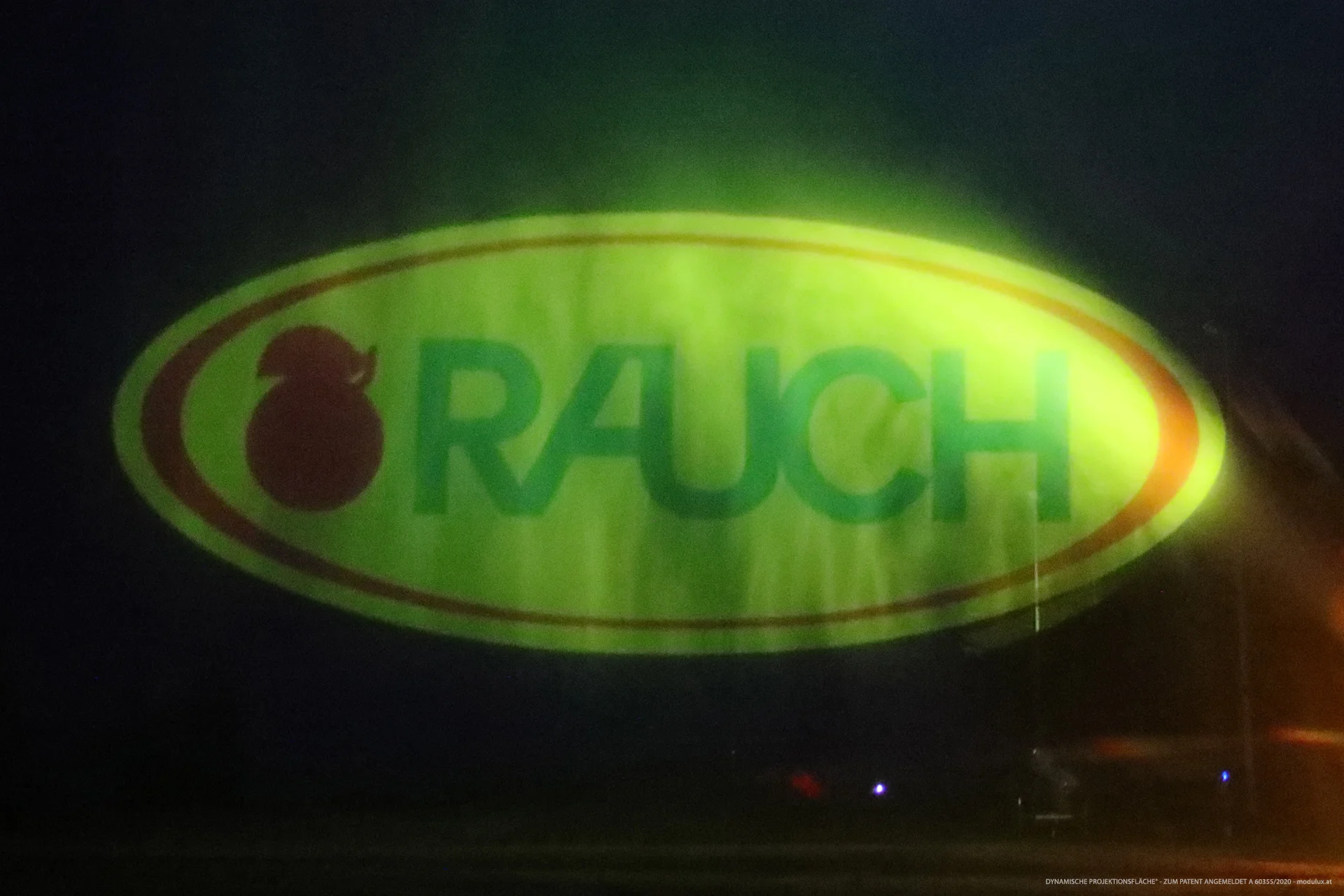 Yellow and green RAUCH logo projected onto water particles