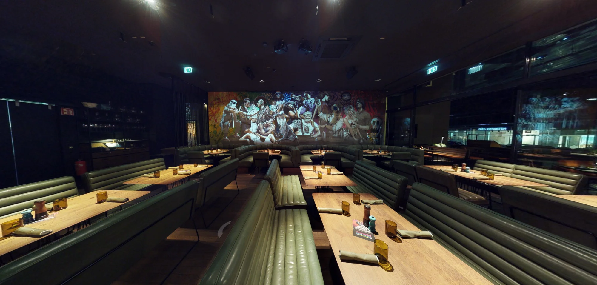 Lange Sitzbank führt zum projizierten Mural am Ende des Restaurants
