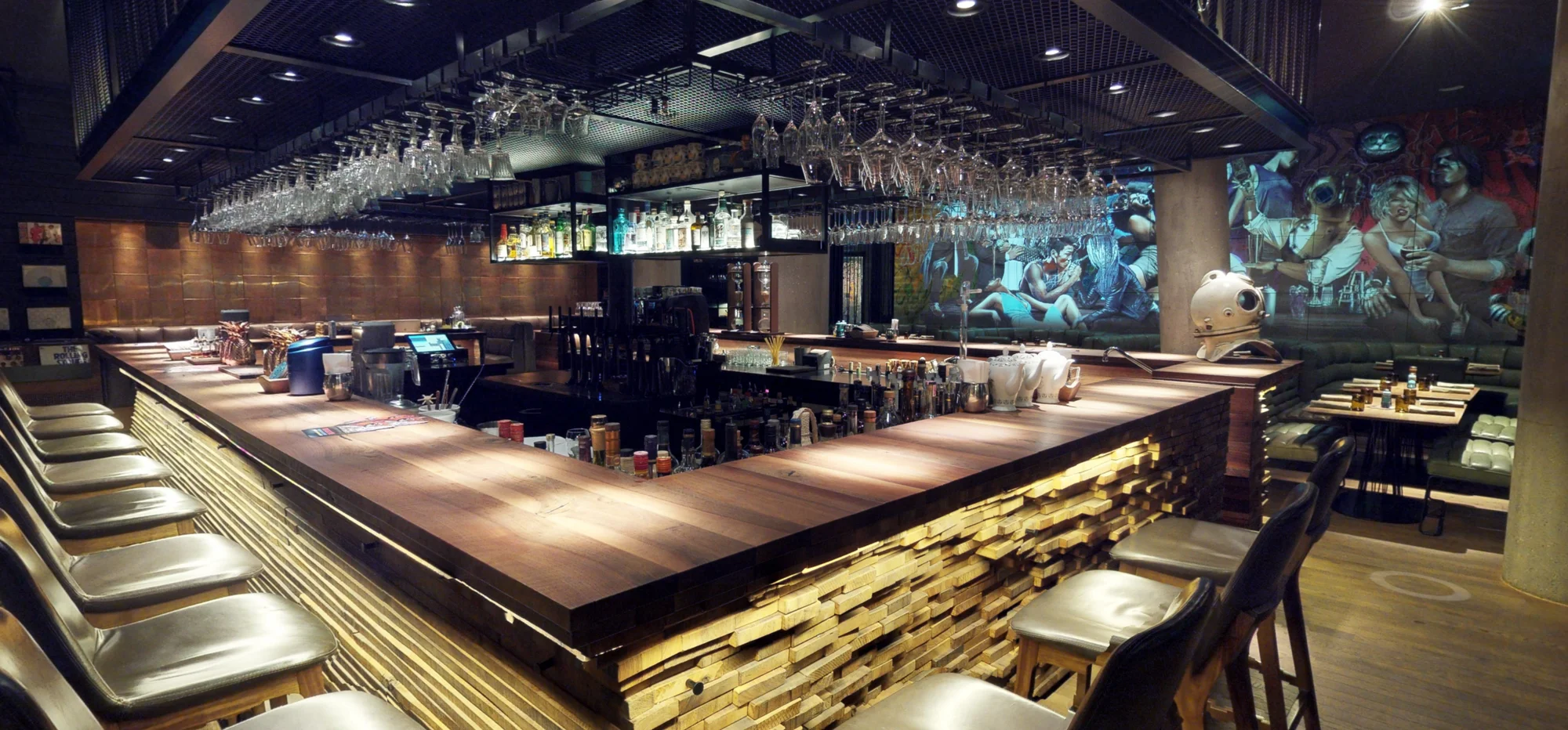 Blick über die Bar auf das projizierte Mural und die Sitzgruppen
