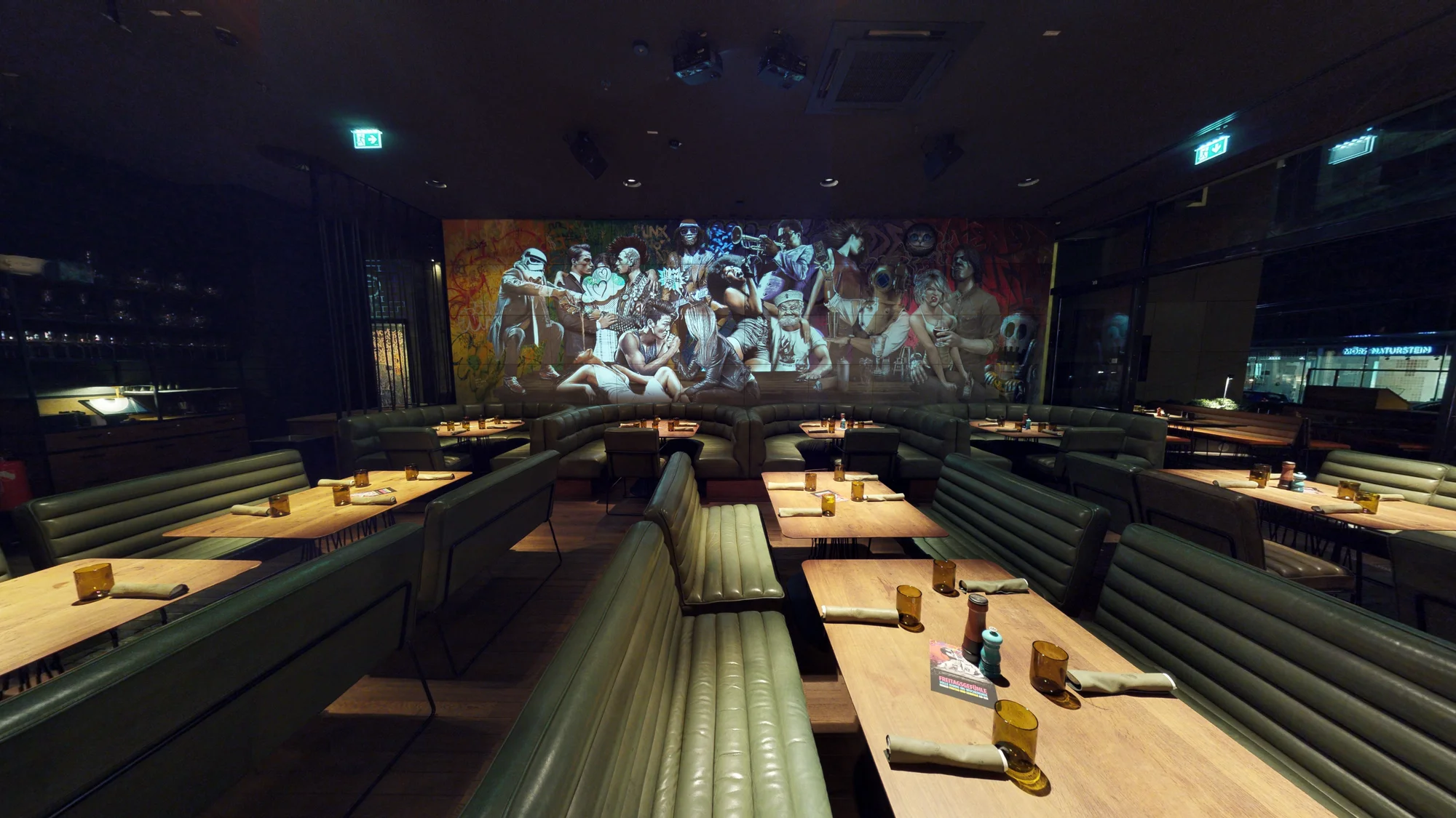 Zentraler Blick entlang der Sitzbank auf die Mural-Projektion