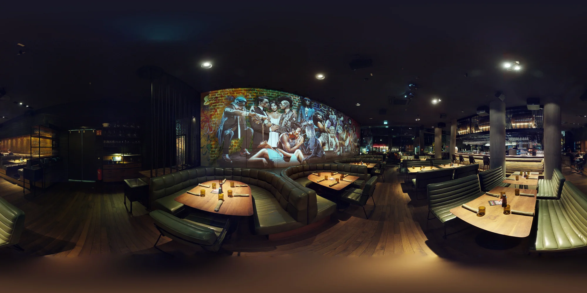 Panorama des Restaurants mit Bar, Sitzgruppen und projiziertem Mural