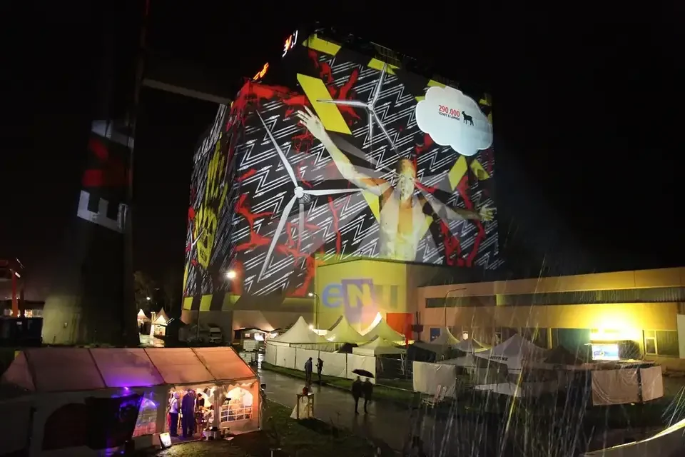 Bunte Bildcollage als Großbildprojektion auf ein Kraftwerksgebäude – TOMORROW FESTIVAL, Kernkraftwerk, Zwentendorf, Österreich